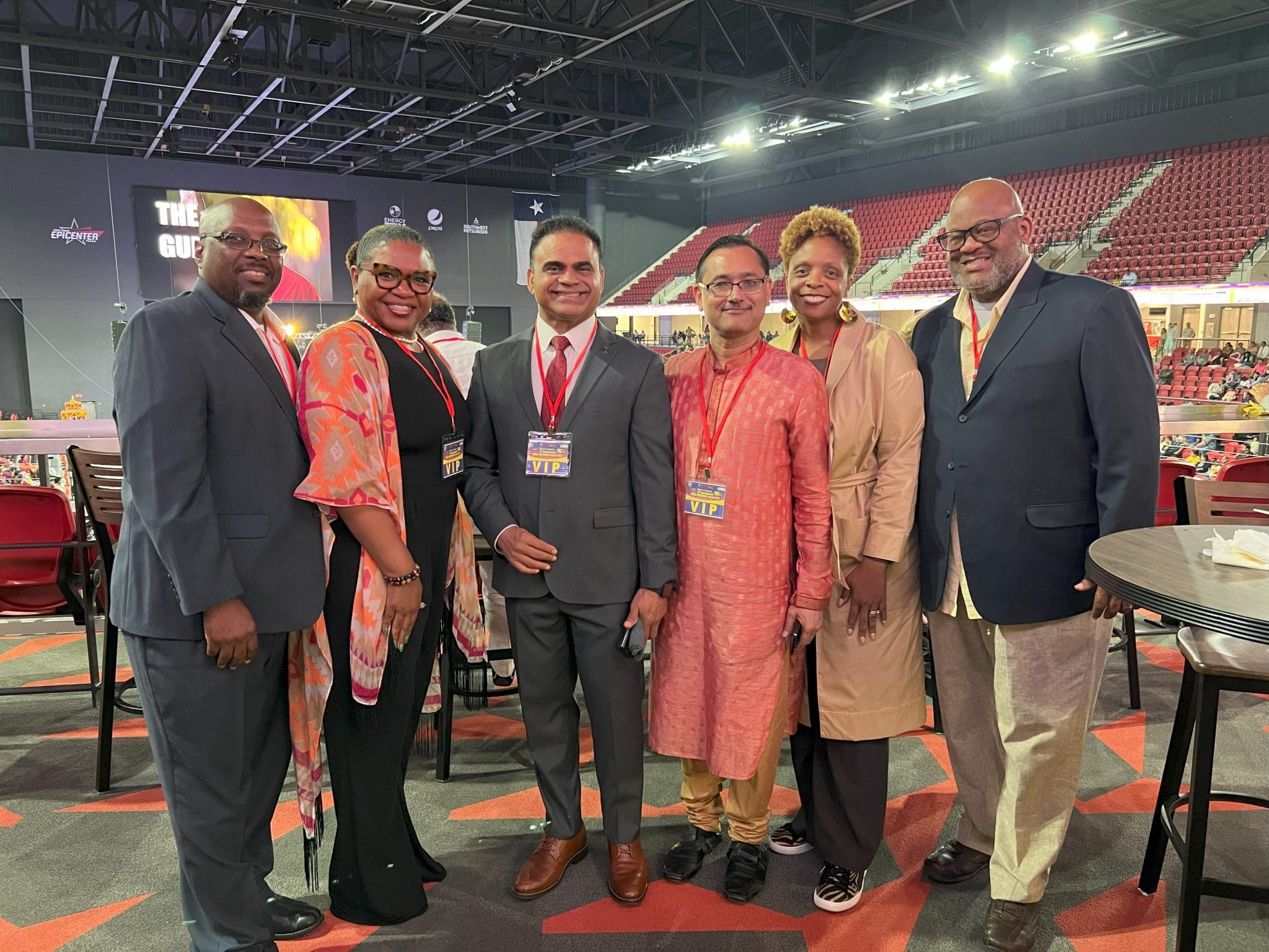 Marquette Greene-Scott with community leaders wearing VIP badges at a large indoor gathering